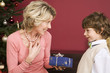 Boy (4-7) giving Christmas present to grandmother, smiling