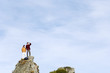 Young couple standing on mountain peak, looking away