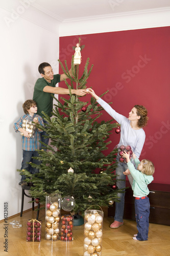Photo: Family decorating Christmas tree Family decorating Christmas tree