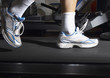 Man's feet on a treadmill in a gym