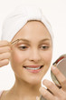 Young woman tweezing her eyebrows, portrait