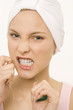Close-up of a young woman flossing her teeth