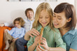 Mother and daughter (8-9), playing recorder