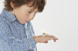 Young boy indoors looking at a moth on hand