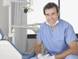 Dentist sitting in examination room smiling