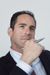 Foto: View of a businessman holding a pen. View of a businessman holding a pen.