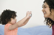 Photo: Hispanic child taking picture of mother Hispanic child taking picture of mother