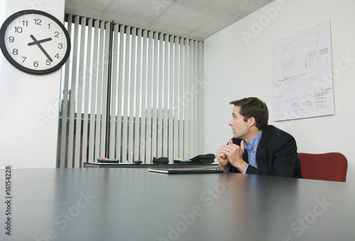 Foto: Businessman looking at a clock Businessman looking at a clock