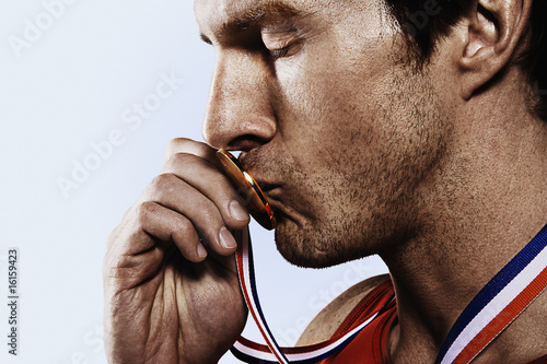 Photo: Athete kissing gold medal Athete kissing gold medal