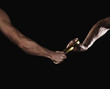 Two relay runners handing off a baton