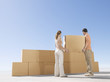 Couple stacking boxes in desert