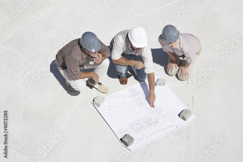 Photo: Architect viewing blueprints with home owners Architect viewing blueprints with home owners
