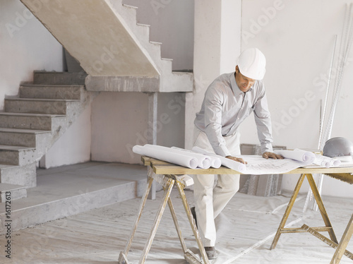 Foto: Architect reviewing blueprints at construction site Architect reviewing blueprints at construction site