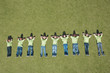 Group of children laying in grass in height ascending order
