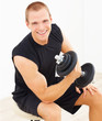 Happy young man exercising with a dumbbell