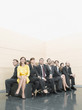 Businesspeople sitting on crowded office bench