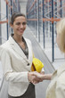 Businesswoman shaking hands in warehouse