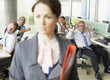Businesspeople making face at boss in office
