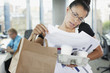 Frustrated businesswoman talking on cell phone with paperwork and coffee