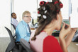Businesswoman in curlers putting on lipstick in office