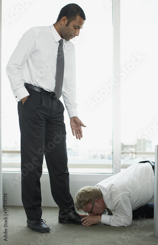 Photo: Businessman kissing boss? feet Businessman kissing boss? feet