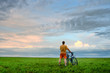 man with bicycle looking at skies
