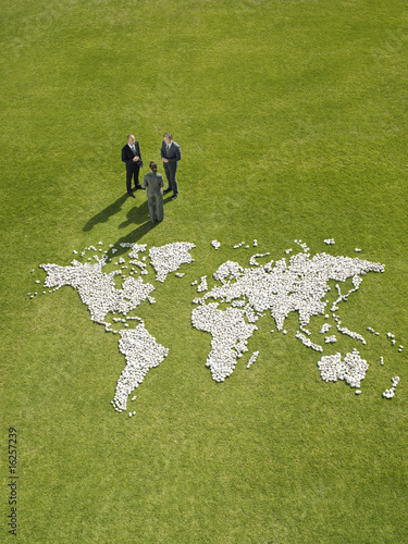 Foto: Businesspeople meeting near?world map made of rocks Businesspeople meeting near?world map made of rocks