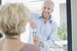 Man opening wine for wife