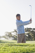 Man playing golf in sand trap