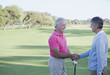 Men shaking hands on golf course