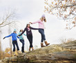 Girls crossing fallen log in a row