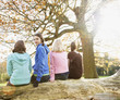 Friends sitting on fallen log