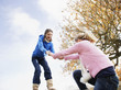 Girl helping friend climb onto log