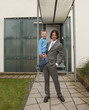 Photo: Father and son standing in front of their house Father and son standing in front of their house
