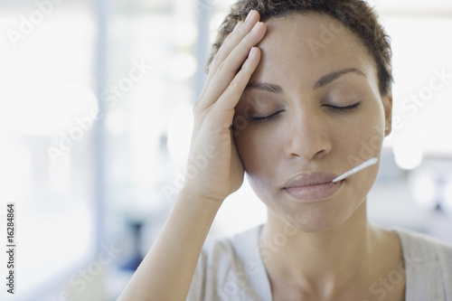 Photo: Sick woman taking her temperature Sick woman taking her temperature