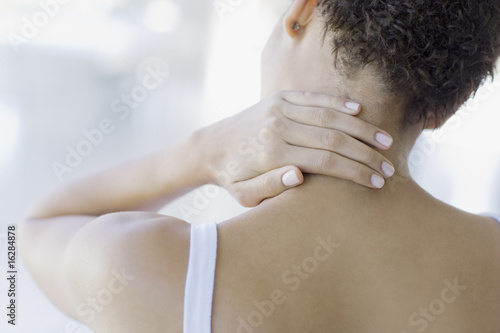Photo: Woman rubbing sore neck Woman rubbing sore neck