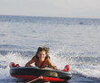 Girl riding raft in ocean