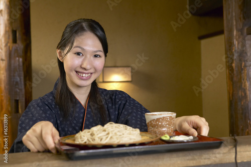 Photo: 蕎麦のトレーを受け取る女性店員 蕎麦のトレーを受け取る女性店員