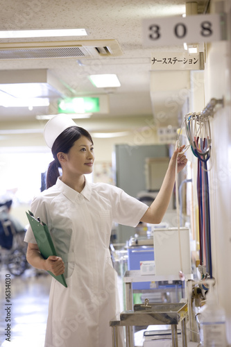 Photo: ナースステーションで準備をする女性看護師 ナースステーションで準備をする女性看護師