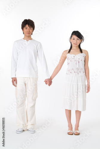 Photo: 手をつないで立っている20代のカップル 手をつないで立っている20代のカップル