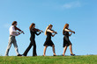 Foto: Four musicians go and playing violins against sky Four musicians go and playing violins against sky
