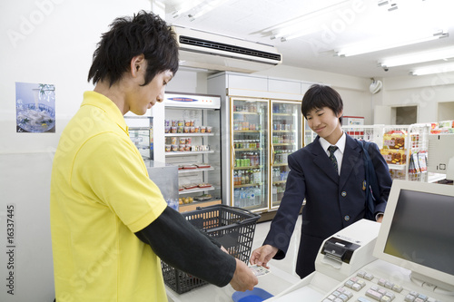 Photo: 会計をする男性店員と高校生 会計をする男性店員と高校生