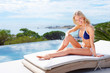 Sunbathing - Happy young woman relaxing on a recliner, outdoors