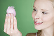 A young woman looking at a pink Easter egg