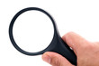 Main tenant une loupe sur fond blanc