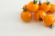 gelbe Kirschtomaten auf weissem Acryl mit Wassertropfen