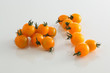 gelbe Kirschtomaten auf weissem Acryl mit Wassertropfen