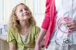 Girl smiling at nurse with stethoscope in examination room