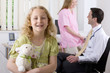 Girl smiling in examination room with doctor and nurse in background