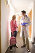 Doctor and girl with backpack talking in corridor